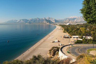 Antalya 'da güneş doğarken Konyaalti plajı ve çam kaplı sahil manzarası