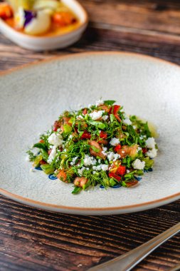 Çürümüş peynir ve domatesli taze bitki salatası.