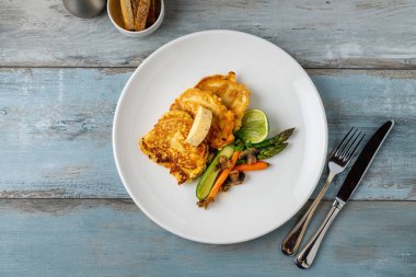 Kuşkonmaz ve havuçla servis edilen sebzeli omlet.