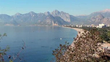 Antalya 'da güneş doğarken Konyaalti plajı ve çam kaplı sahil manzarası