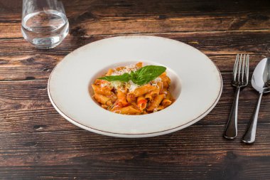 İçinde taze fesleğen ve domates sosu olan makarna.