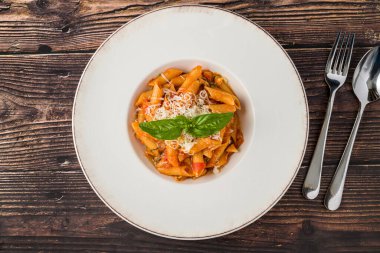 İçinde taze fesleğen ve domates sosu olan makarna.