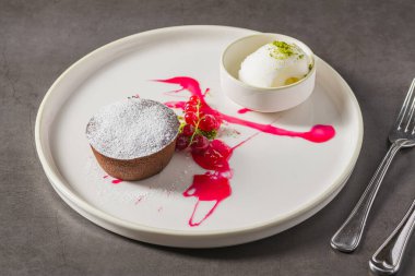 Sıcak çikolatalı lav keki, ortasından akan ve pudra şekerli.