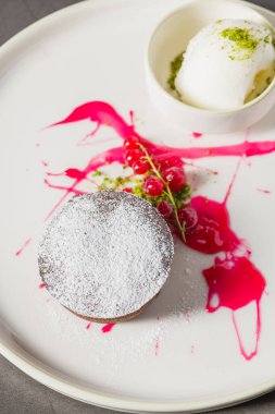 Sıcak çikolatalı lav keki, ortasından akan ve pudra şekerli.