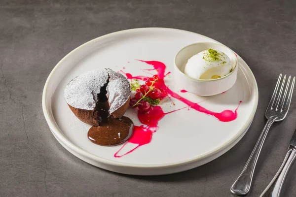 Sıcak çikolatalı lav keki, ortasından akan ve pudra şekerli.