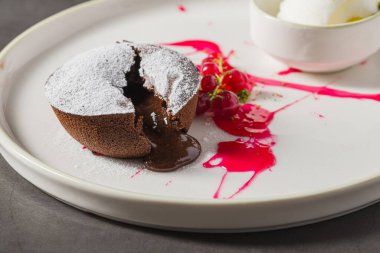 Sıcak çikolatalı lav keki, ortasından akan ve pudra şekerli.