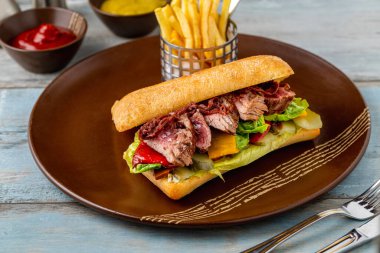 Kızarmış biftekli sandviç ve patates kızartması.