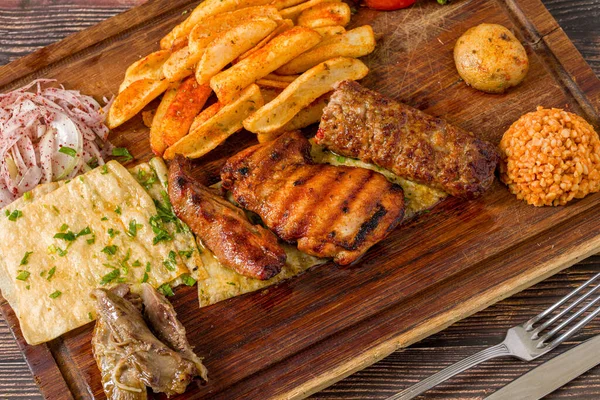 Geleneksel Türk karışık ızgara tabağı ahşap tabakta servis ediliyor