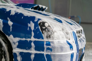 Mavi arabayı temizleme köpüğünün altına, oto yıkama servisinin içine kapat.