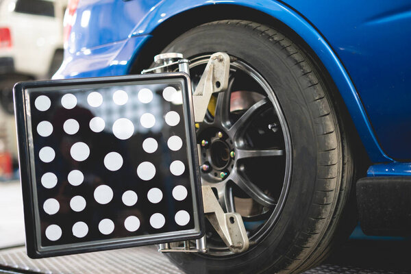 a car in service with sensors on the wheels to check alignment camber toe