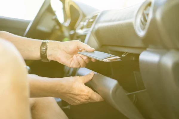 person\'s hand take wallet cash and credit card from the glove compartment in the car