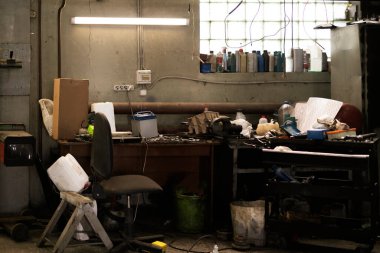 Eski, tozlu bir araba servisi atölyesi.