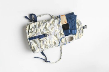 Yukardan bir manzara, içinde eşyalar ve giysiler olan sıradan bir sırt çantası, yerleştirmeye ve paketlemeye hazır.