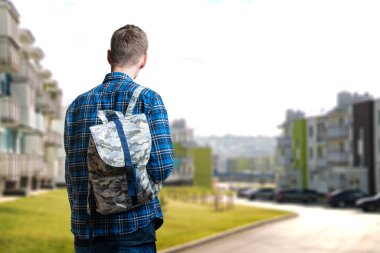 Sırt çantasıyla yürüyen genç bir erkek basit, izole bir kavram, bir şeyler taşır.