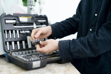 Projeyi yapmak için set dosyasından aracı alan işçi el