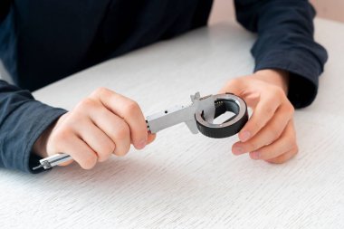 Mühendis el çalışıyor ve kalibreli araçla parçaları ölçüyor