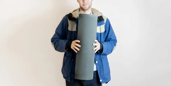 Egy fiatal férfi kezében egy jóga szőnyeg, és vigye az osztály, másolás tér, sport és fitness koncepció — Stock Fotó