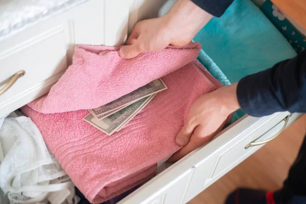 Mano tomando escondite oculto de dinero en efectivo del armario en casa — Foto de Stock