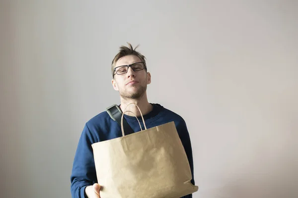 Молодой человек с бумажным пакетом, доставить товар — стоковое фото