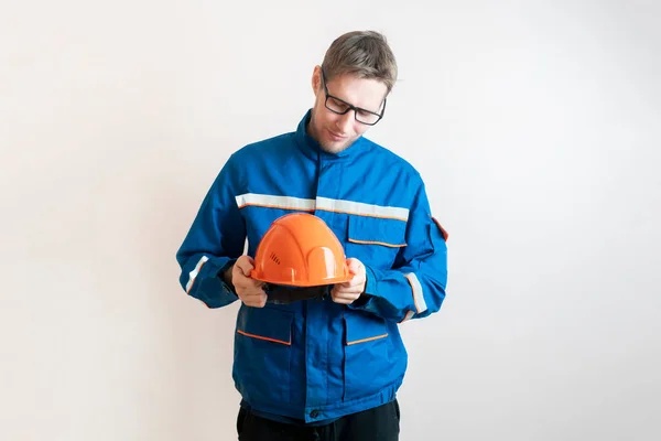 Egy fiatal férfi munkás kezében sisak, ipari biztonsági berendezések — Stock Fotó