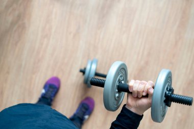 Ev işi yapan bir kişi birkaç dambıl teçhizatıyla.