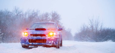 Hızlı mavi spor araba kışın karlı gün, soğuk mevsim, sokak yolu