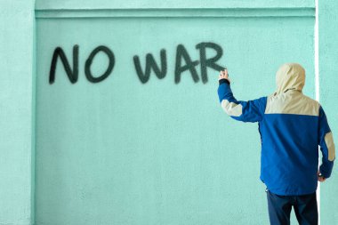 Bir erkek sprey boyayla yazarsa duvara savaşı durdurabilir mi, grafiti sembolü konsepti...