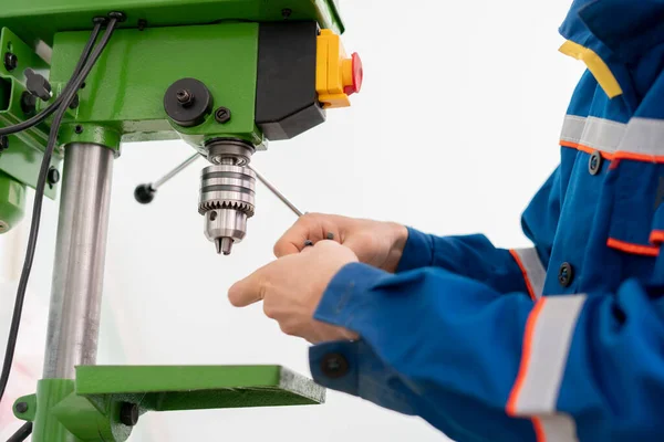 A close up young male worker using a drill machine on the factory —  Fotos de Stock
