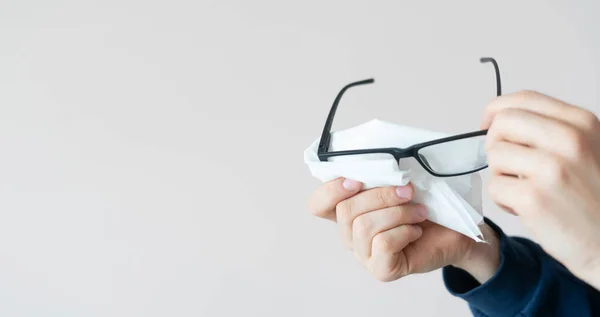 Une personne mains tenant des lunettes de vue et essuyez les lentilles, vue dégagée — Photo