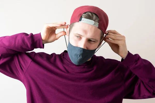 Um jovem do sexo masculino usar a máscara têxtil preta para proteger do vírus covid-19, roupas de estilo de vida casual — Fotografia de Stock