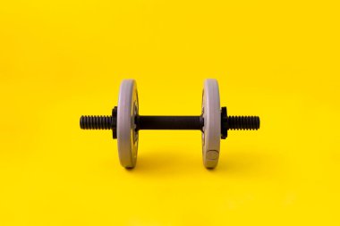 Tek gri ağırlıklı dambıl, arka planda izole edilmiş spor vücut geliştirme ekipmanı.