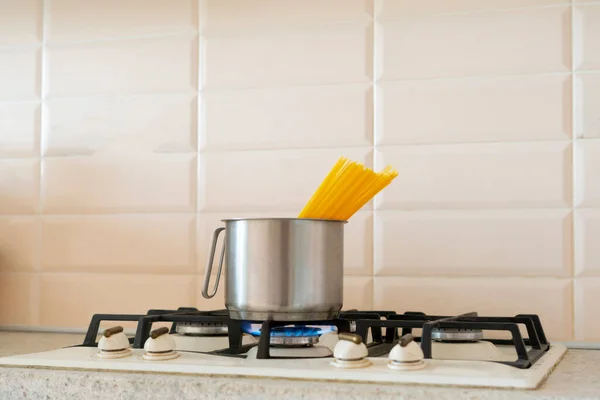 Un spaghetti cuit dans la casserole à l'eau bouillante sur la cuisinière dans la cuisine — Photo