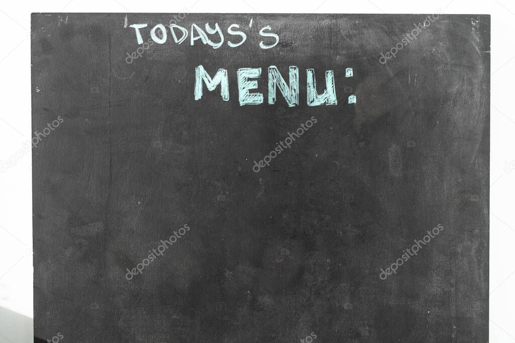 a black chalkboard with menu text in the street restaurant