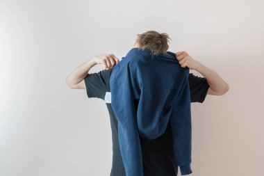 Bir adam kapüşonlu kazak giydi.