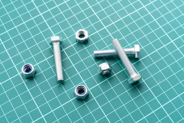 A silver stainless steel nuts and bolts flat lay on the table, minimalistic concept — Stockfoto