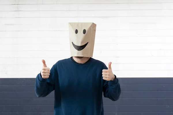 Une personne avec un sac en papier sur la tête avec un sourire, concept heureux succès — Photo