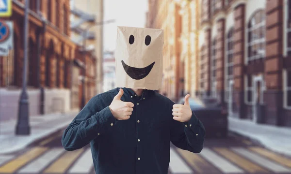 Uma pessoa com saco de papel na cabeça com um sorriso, conceito de sucesso feliz — Fotografia de Stock