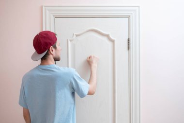 Bir insan eli kapıyı çalar, arkadaşının evini ziyaret eder.