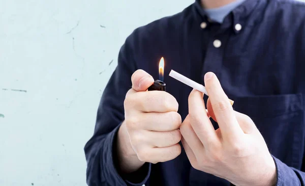 Una persona sosteniendo una llama de encendedor de chispa y un cigarrillo, fumar mal habbit —  Fotos de Stock