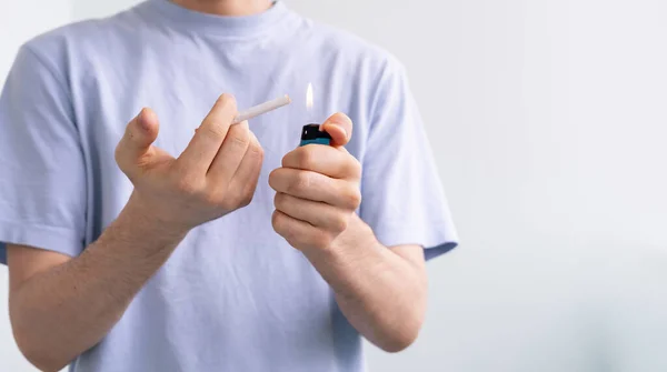 Uma pessoa segurando uma chama mais leve faísca e um cigarro, fumando mau habbit — Fotografia de Stock