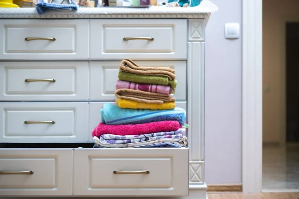 Una pila de nuevas toallas limpias de color fresco textil en el estante en la lavandería — Foto de Stock