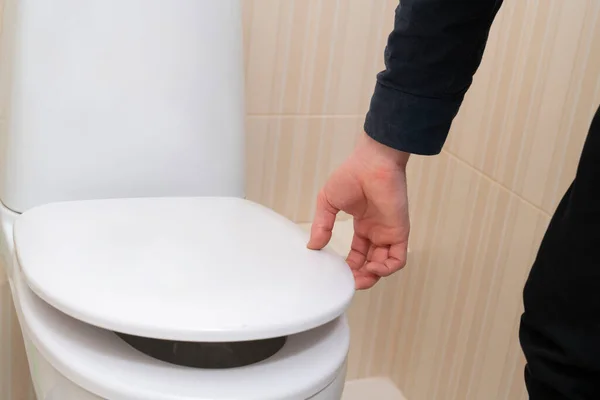 Uma mão abrir a tampa do banheiro, casa casa casa sanitária — Fotografia de Stock