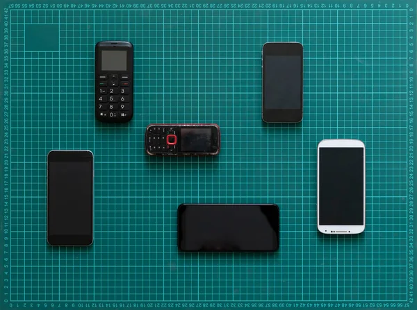 Un concepto de evolución de la tecnología, algunos teléfonos celulares antiguos y nuevos dispositivos nodern —  Fotos de Stock