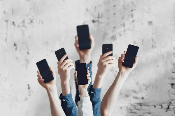 Большая группа людей держат цифровые телефоны устройство, многие человеческие руки — стоковое фото
