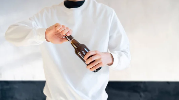 Egy férfi kinyitja az üveg sörösüveg party, rossz szokás, alkoholista — Stock Fotó