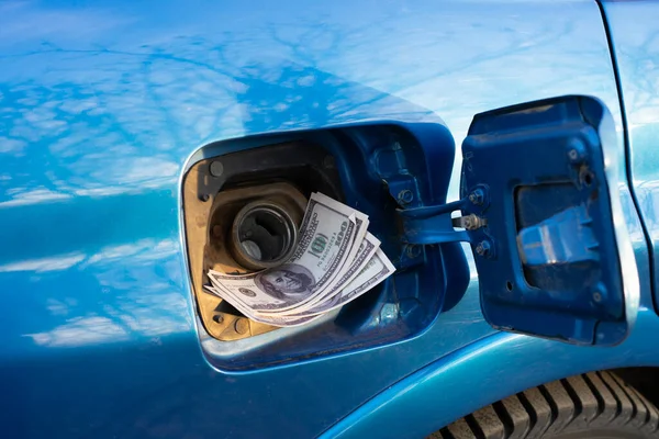 the refill the car with fuel, some cash money inside the fuel tank, idea of expensive gasoline