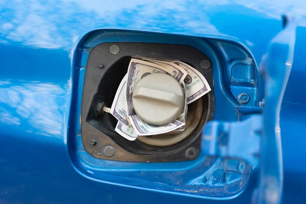 the refill the car with fuel, some cash money inside the fuel tank, idea of expensive gasoline