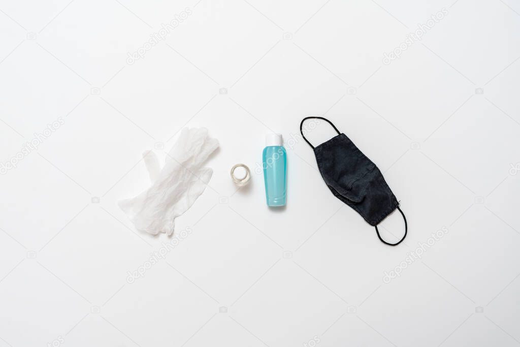 a flat lay of some protective equipment supplies for coronavirus pandemic virus, antiseptic, mask and gloves
