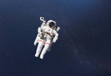 Uzay boşluğunda bir kozmonot. Yıldızlar ve ışık huzmesi olan bir galaksi arkaplanı. Bu görüntünün unsurları Nasa tarafından desteklenmektedir