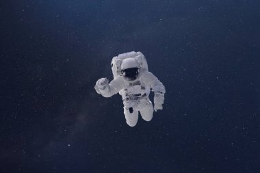 Uzay boşluğunda bir kozmonot. Yıldızlar ve ışık huzmesi olan bir galaksi arkaplanı. Bu görüntünün unsurları Nasa tarafından desteklenmektedir